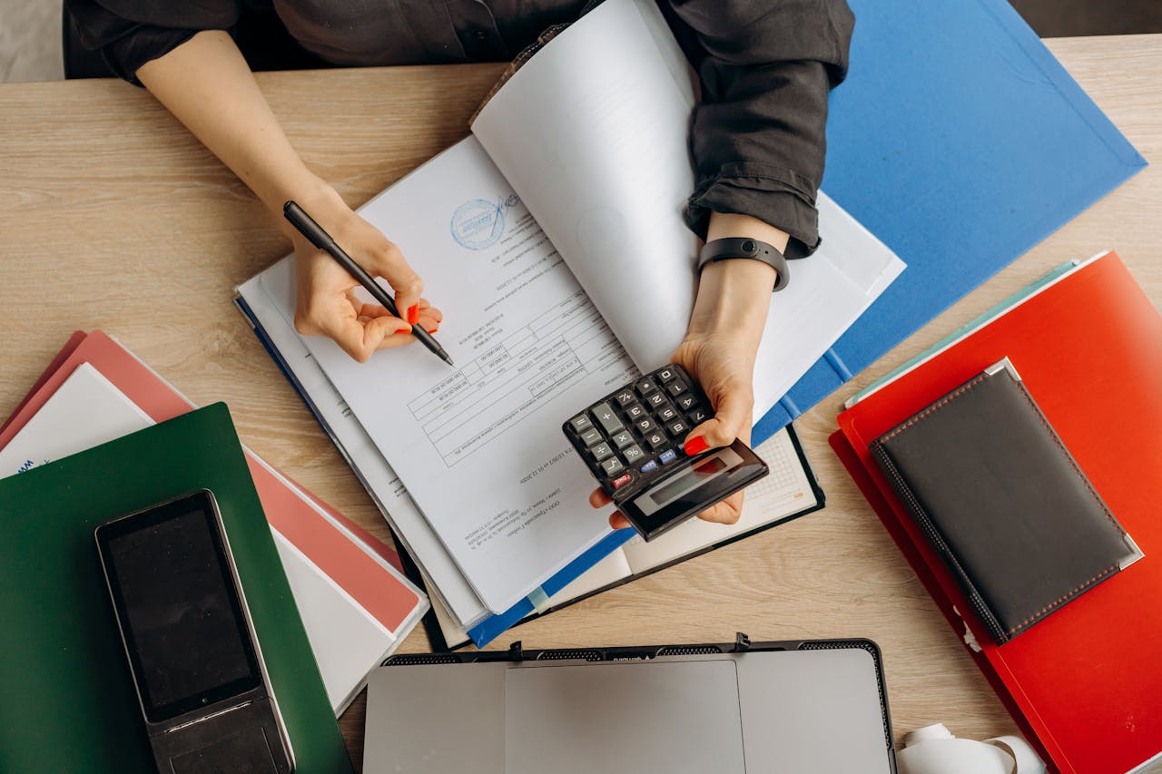 team-01 Accountant analyzing financial documents with a calculator on a desk, highlighting business tasks.
