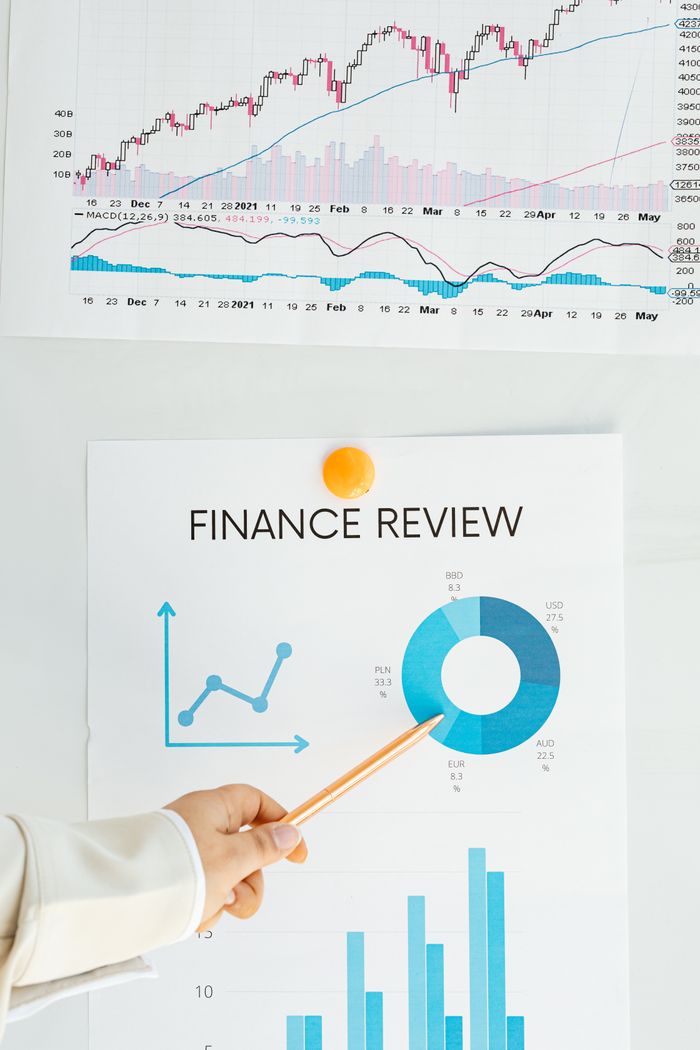 services-01 Close-up of financial analysis showing graphs, charts, and person pointing with pencil.